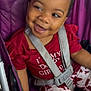 Alaia Noell is registered to the contest to win money with this photo: toddler, child, smiling, stroller, purple, hair_beads, red_shirt, patterned_pants, seatbelt, happy, baby, cute, portrait, sitting, infant, clothing, seat, baby_girl, expression, indoors
