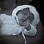 baby, sleeping, lace, white_clothing, person, arm, portrait, black_and_white, peaceful, child, newborn, infant, closeup, soft_light, fabric, holding, face, cute, tender, calm