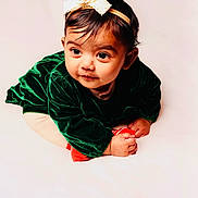 Aaira Ghosh joined the competition — help win amazing prizes! baby, infant, child, portrait, headband, green_dress, velvet, cute, curious, soft_lighting, studio, white_background, hands, face, looking_away, young, adorable, crawling, clothing, expression