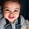 baby, baby_carrier, blanket, child, closeup, cute, expression, eyes, face, funny_face, gray_shirt, happy, indoor, infant, person, portrait, smiling, teeth, toddler, young_child