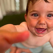 Andrea participe au concours pour gagner de l'argent avec cette photo : baby, blurred_background, child, closeup, curious, cute, eyes, face, fingers, hand, happy, indoor, infant, mouth, person, portrait, skin, smiling, teeth, young
