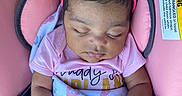 Amelia is registered to the contest to win money with this photo: baby, sleeping, pink_bow, headband, blanket, car_seat, infant, peaceful, child, bracelet, pacifier, clothing, warning_label, seatbelt, toddler, cute, portrait, indoor, closeup, resting