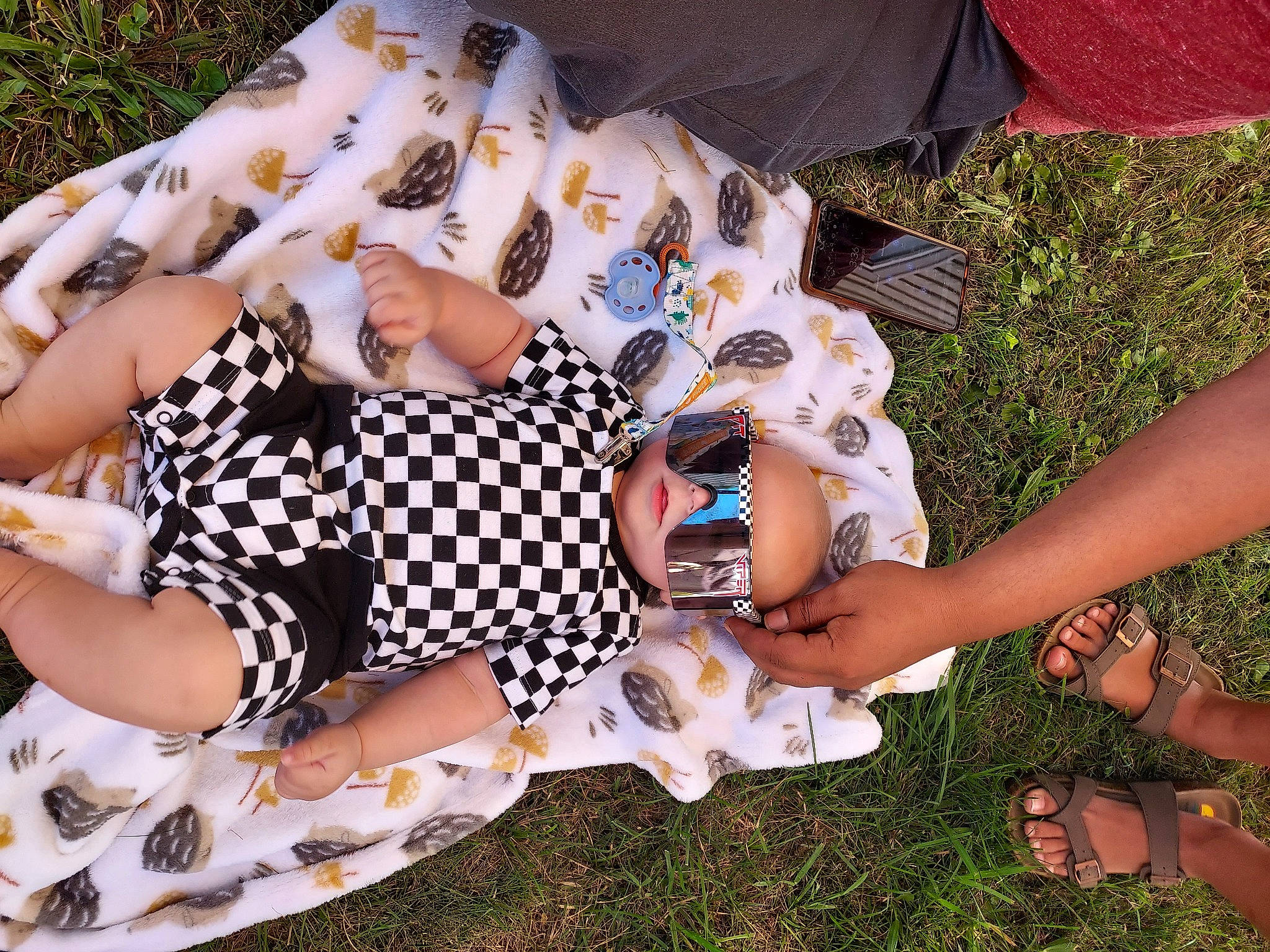 Leon is registered to the contest to win money with this photo: child, cool, eyewear, fashion, fashion_accessory, finger, fun, goggles, grass, happy, human, human_leg, leaf, leisure, nail, pattern, people_in_nature, person, recreation, sunglasses