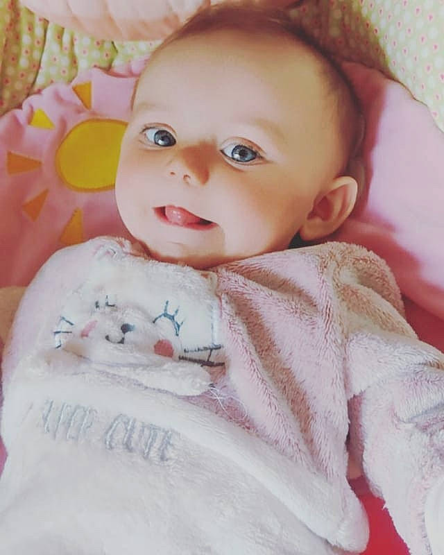 Lévana a rejoint le concours — aidez-le/la à gagner de superbes lots ! baby, baby_toddler_clothing, cheek, comfort, dress, eye, eyebrow, eyelash, face, iris, linens, lip, pattern, person, pink, product, skin, sleeve, smile, textile