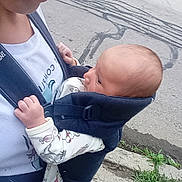 Oliver is registered to the contest to win money with this photo: baby, child, adult, baby_carrier, outdoor, sidewalk, street, clothing, person, infant, holding, residential_area, grass, crack, road, casual_wear, head, face, young_adult, daytime