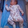 baby, sleeping, crib, blanket, toy, soft_toy, infant, onesie, footed_pajamas, sleepwear, child, indoor, peaceful, rest, colorful, furniture, bed, head, person, nursery
