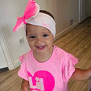 Amelia participe au concours pour gagner de l'argent avec cette photo : toddler, child, smiling, headband, pink_clothing, indoor, wooden_floor, happy, person, cute, baby, short_sleeves, girl, portrait, young_child, fashion, accessory, casual_wear, standing, bright_colors