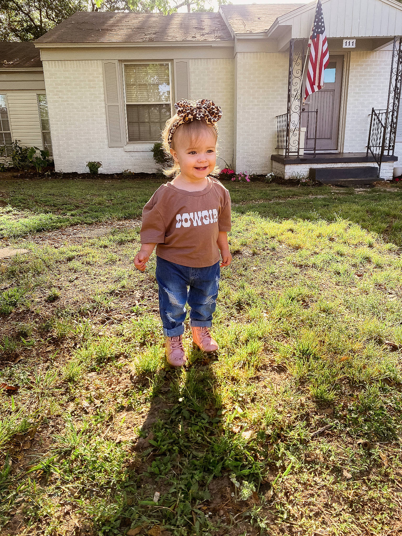 Reagan is registered to the contest to win money with this photo: cottage, fun, garden, grass, grass_family, grassland, happy, home, house, joy, landscape, lawn, people_in_nature, person, plant, soil, stairs, t_shirt, tints_and_shades, toddler