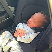 Nwaora is registered to the contest to win money with this photo: baby, newborn, car_seat, sleeping, child, infant, seatbelt, clothing, polka_dots, white_outfit, car_interior, peaceful, hands, head, person, transportation, safety, indoors, seat, resting