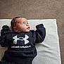 Nwaora is registered to the contest to win money with this photo: baby, infant, under_armour, black_clothing, cushion, carpet, lying_down, blue_eyes, curious, indoor, child, sweatshirt, pants, person, portrait, casual, comfortable, young, cute, cozy