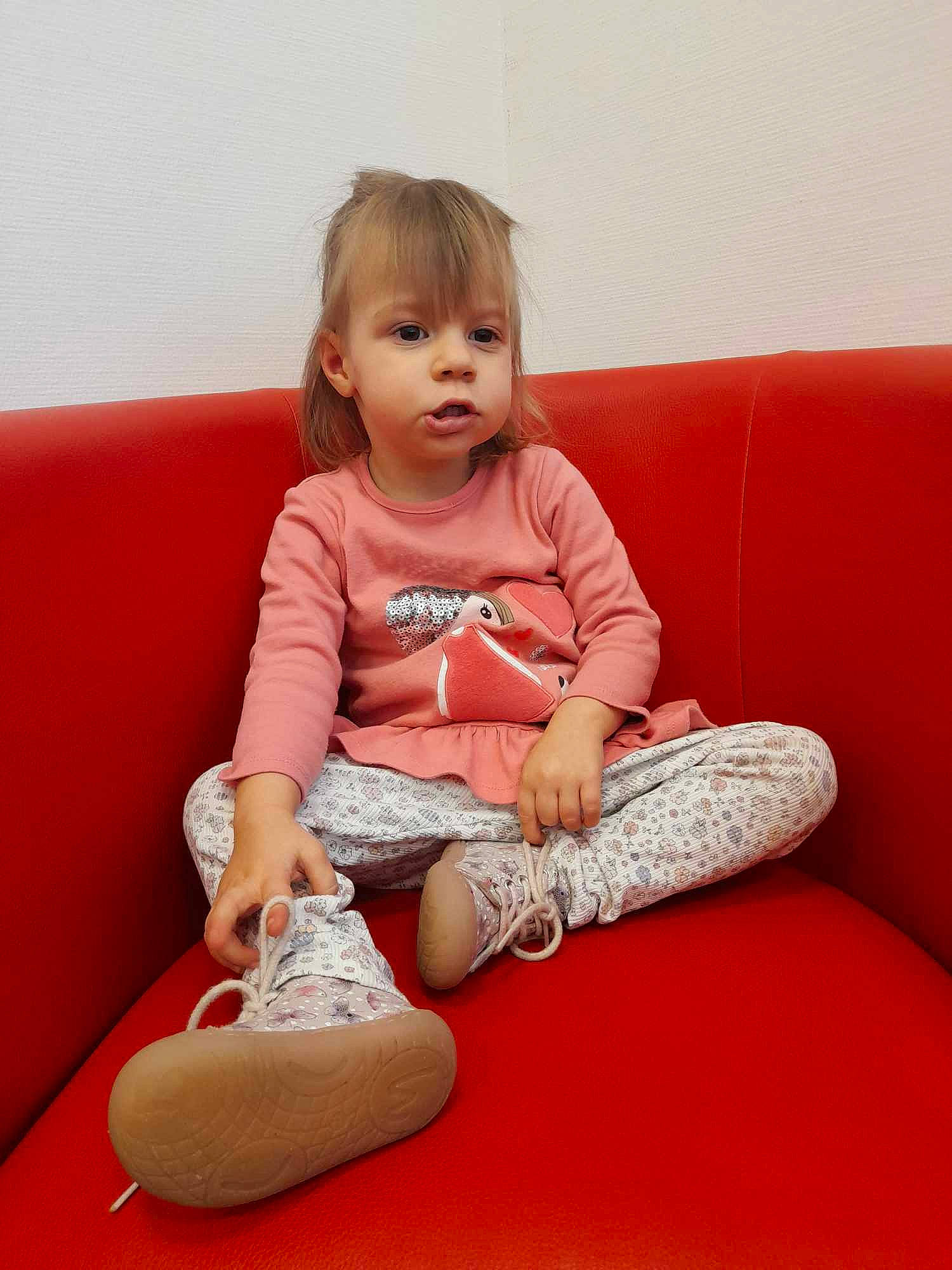 Lola a rejoint le concours — aidez-le/la à gagner de superbes lots ! baby_toddler_clothing, child, comfort, flooring, fun, happy, head, human_leg, knee, lap, leg, magenta, person, pink, shoe, sitting, sleeve, t_shirt, thigh, toddler