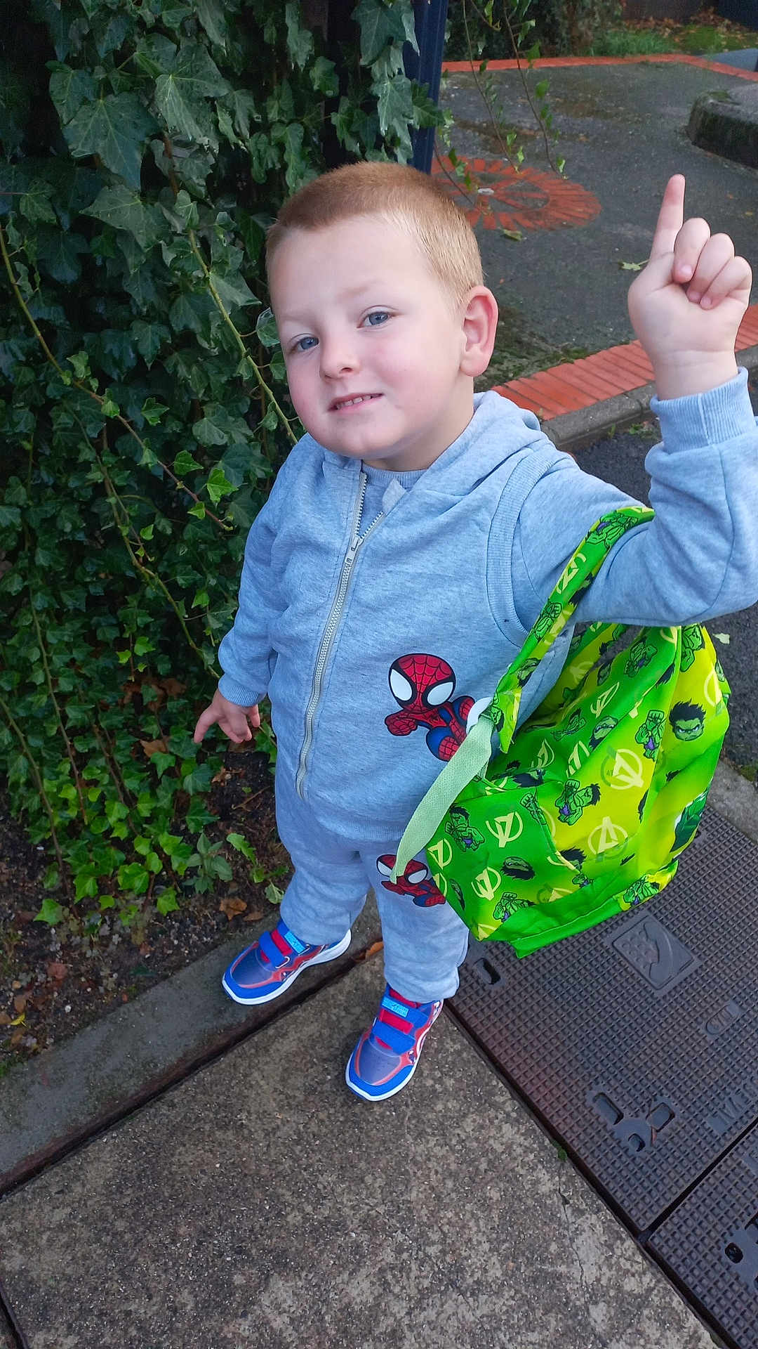 Nelson a rejoint le concours — aidez-le/la à gagner de superbes lots ! child, boy, outdoor, ivy, sidewalk, concrete, bag, avengers, spiderman, tracksuit, sneakers, pointing, green, playful, casual, smile, urban, young, person, daytime