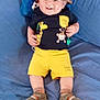 Nelson a rejoint le concours — aidez-le/la à gagner de superbes lots ! baby, child, smiling, hat, tshirt, shorts, sandals, socks, bed, pillow, blue_bedspread, lying_down, happy, indoor, cute, infant, clothing, footwear, person, portrait