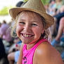 child, smile, hat, pink_tank_top, outdoor, portrait, happy, gap_tooth, face, blond_hair, summer, crowd, people, casual_clothing, daylight, skin, shoulder, close_up, blue_eyes, fun