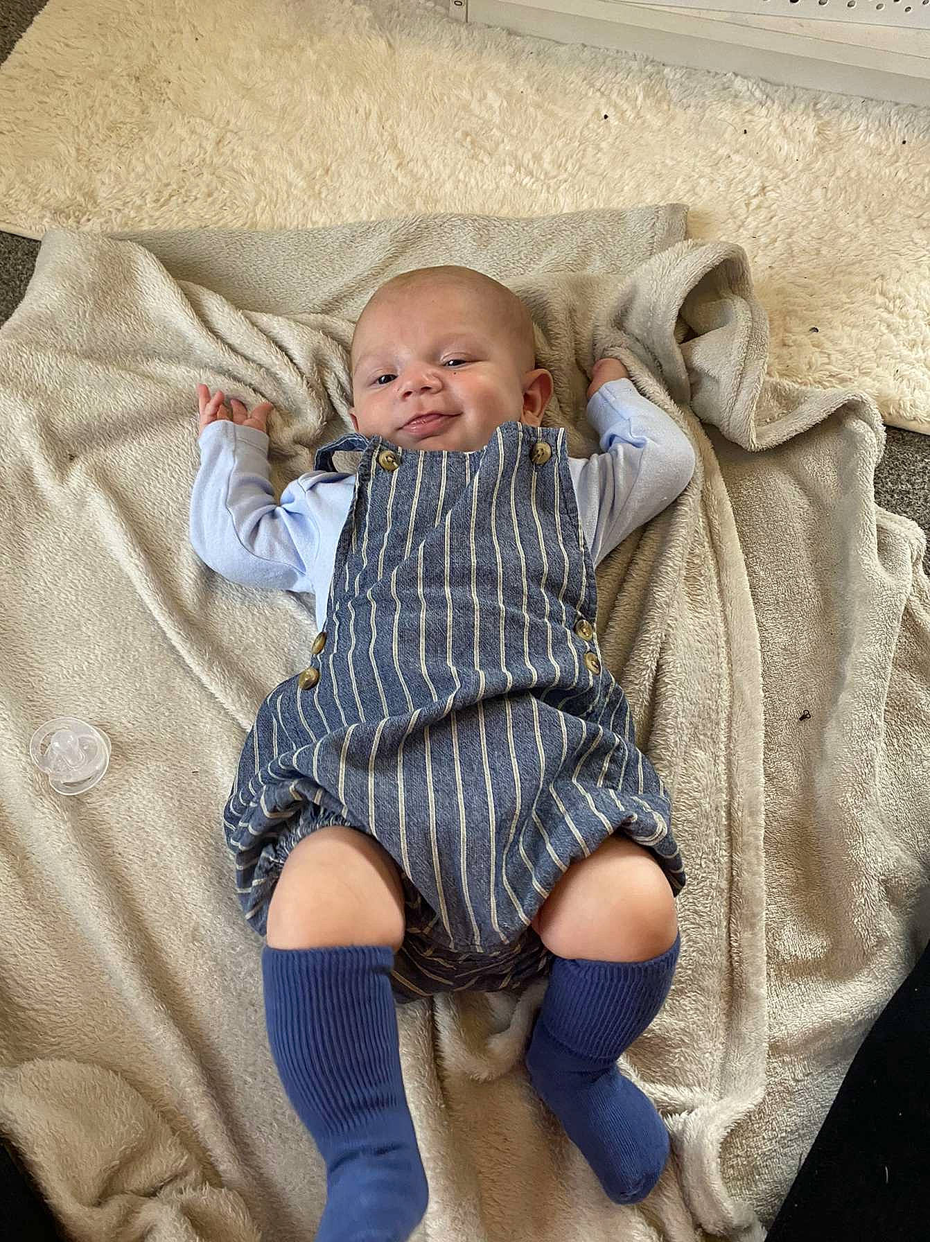 Kyson is registered to the contest to win money with this photo: baby, baby_toddler_clothing, comfort, eye, foot, fur, head, human_body, human_leg, lap, leg, linens, pattern, person, sitting, sleeve, smile, sock, textile, thigh