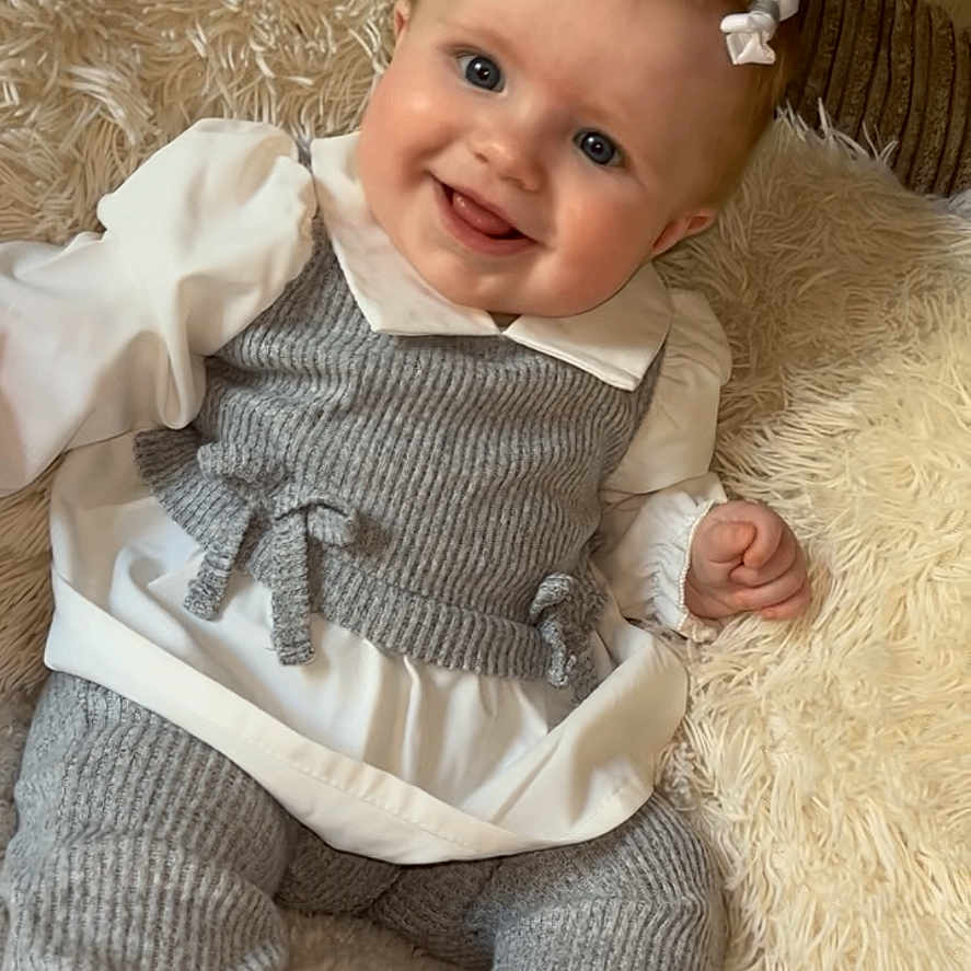 Harlow is registered to the contest to win money with this photo: baby, bodypart, clothing, couch, cushion, dress, face, finger, furniture, hand, happy, head, homedecor, newborn, pants, person, photography, portrait, sitting, smile