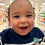 Maho participe au concours pour gagner de l'argent avec cette photo : toddler, child, smiling, face, curly_hair, teeth, striped_shirt, dinosaur_patch, indoor, store, aisle, products, bright_lighting, happy, portrait, person, clothing, cute, baby, close_up