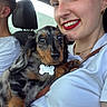 Babinks participe au concours pour gagner de l'argent avec cette photo : woman, dog, puppy, dachshund, car, smile, red_lipstick, bracelet, watch, white_shirt, seat, window, pet, holding, cute, portrait, jewelry, happy, indoor, closeup