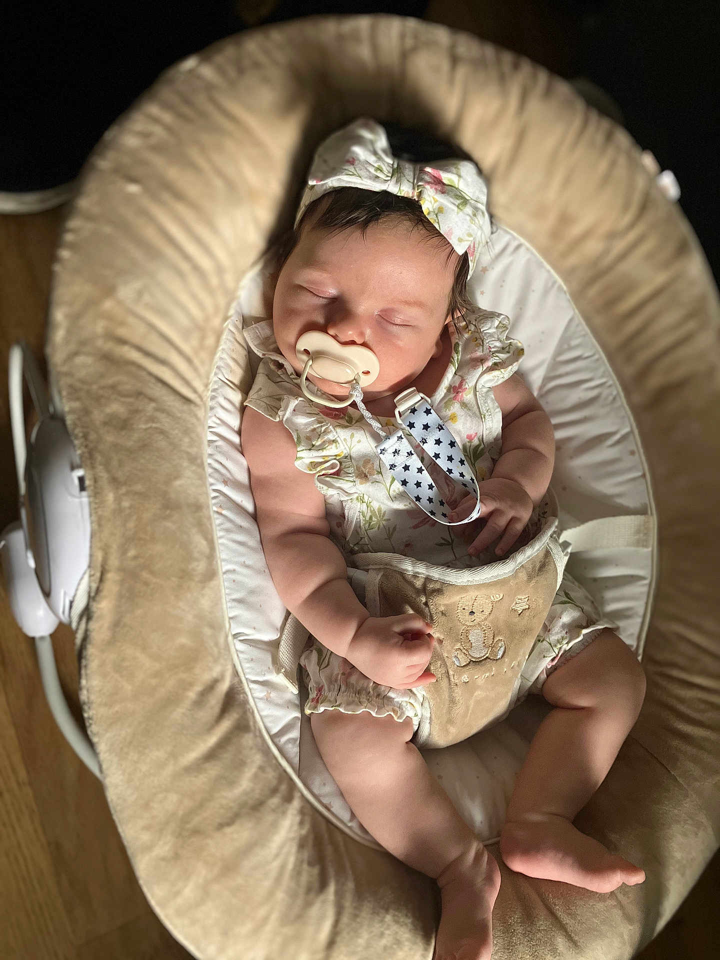 Lilith is registered to the contest to win money with this photo: baby, sleeping, pacifier, headband, baby_rocker, cushion, infant, clothing, hand, foot, wooden_floor, comfort, peaceful, cute, soft_light, indoor, child, adorable, plush, resting