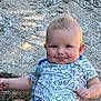 Jesse is registered to the contest to win money with this photo: baby, blonde, bodypart, clothing, face, finger, frown, hair, hand, happy, head, pants, person, photography, portrait, road, rock, sitting, smile, t_shirt