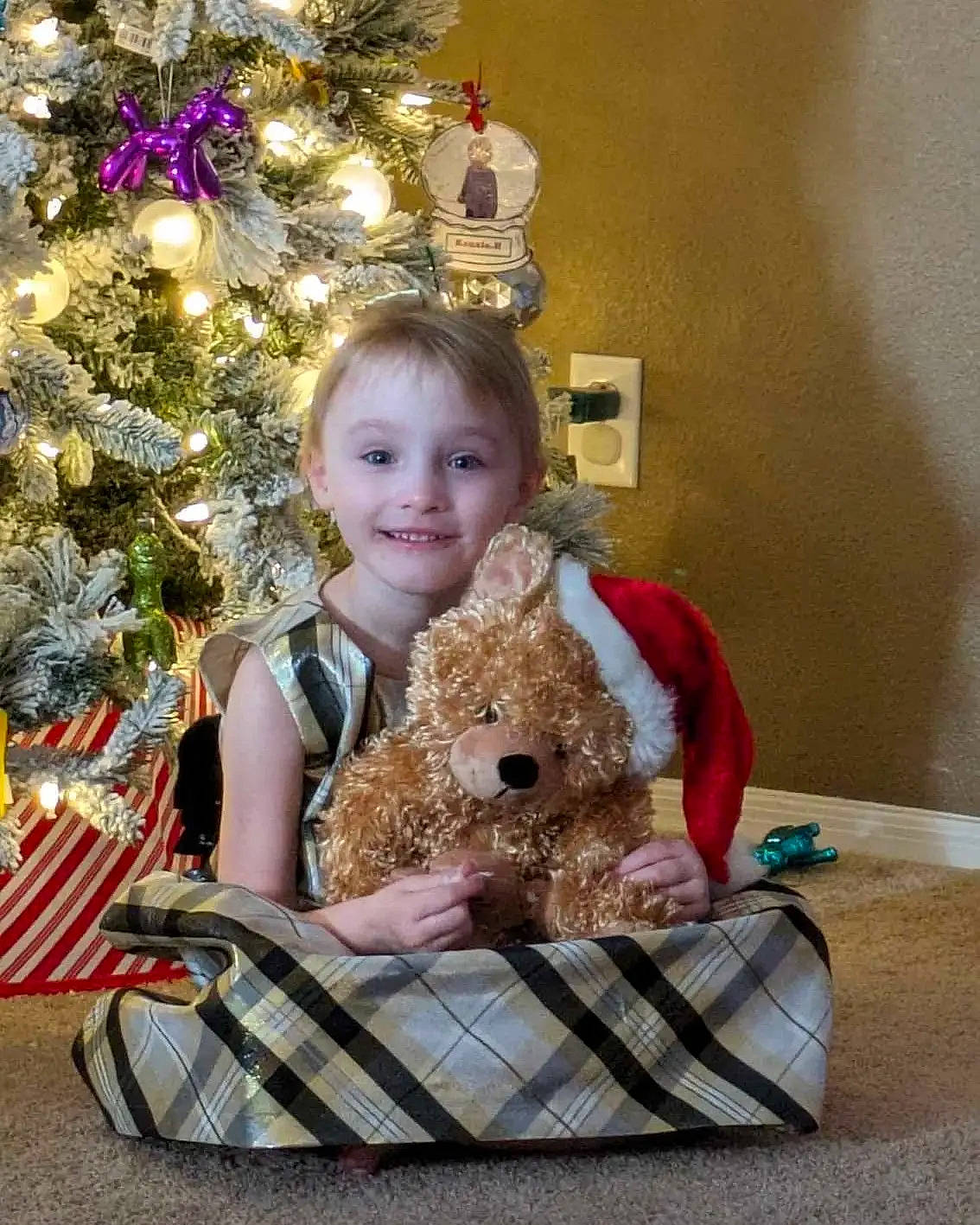 Kenzie joined the competition — help win amazing prizes! child, christmas, christmas_decoration, christmas_ornament, christmas_tree, companion_dog, doll, dress, event, eye, happy, head, holiday, holiday_ornament, joy, ornament, person, room, sitting, smile