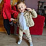 Noah participe au concours pour gagner de l'argent avec cette photo : toddler, child, indoor, living_room, red_couch, wooden_floor, jacket, pants, white_shirt, sneakers, lamp, staircase, coat, cat_tree, pacifier, playful, person, furniture, clothing, floor