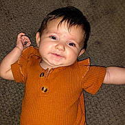 Adalyn is registered to the contest to win money with this photo: baby, infant, child, smile, face, eyes, hair, carpet, clothing, orange, cute, portrait, happy, skin, person, indoors, texture, button, sleeve, lying_down