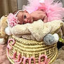 Eyma participe au concours pour gagner de l'argent avec cette photo : baby, basket, blanket, cozy, cute, eyes, face, flower, headband, indoor, infant, lying_down, name, pink_tutu, pom_poms, portrait, soft, toddler, woven, yarn
