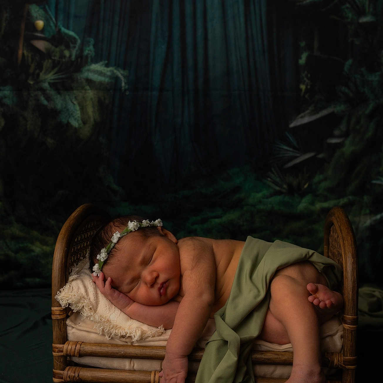 Blesslyn is registered to the contest to win money with this photo: baby, bed, blanket, child, cozy, cute, dark_background, flower_crown, forest_theme, green_cloth, indoor, infant, newborn, peaceful, portrait, resting, sleeping, soft_lighting, toddler, wooden_bed