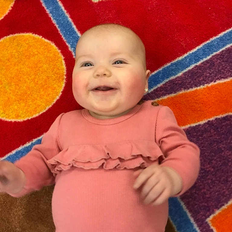 Khylinn joined the competition — help win amazing prizes! baby, casual, child, colorful, cute, face, hand, happy, head, indoor, infant, patterned_carpet, person, pink_clothing, playful, portrait, skin, smiling, toddler, young_child