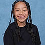 Brayden is registered to the contest to win money with this photo: child, smiling, portrait, braids, black_shirt, school_photo, gap_toothed, happy, studio_backdrop, blue_background, face, teeth, headshot, casual_clothing, cute, natural_hairstyle, long_braids, eyes_open, front_facing, sitting