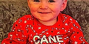 Leo joined the competition — help win amazing prizes! toddler, child, smile, red_sweater, candy_cane_pattern, stars, sitting, couch, indoor, happy, face, holiday, festive, young_child, portrait, clothing, cozy, cute, person, casual