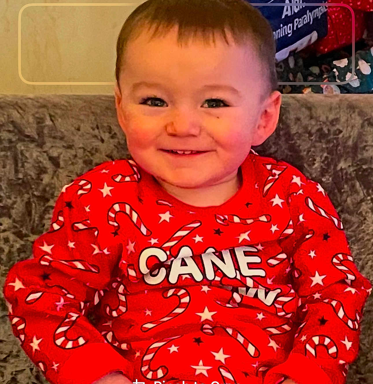 Leo joined the competition — help win amazing prizes! toddler, child, smile, red_sweater, candy_cane_pattern, stars, sitting, couch, indoor, happy, face, holiday, festive, young_child, portrait, clothing, cozy, cute, person, casual