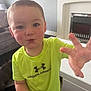Leo joined the competition — help win amazing prizes! child, toddler, boy, indoor, living_room, under_armour, green_shirt, face, hand, smiling, curtains, fireplace, couch, white_furniture, carpet, toy, sneaker, hair, skin, expression