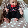 apparel, baby, black_pants, blanket, bow_tie, chair, child, cozy, curious, cute, feet, furniture, heart_pattern, indoor, infant, person, plush, portrait, seated, shirt