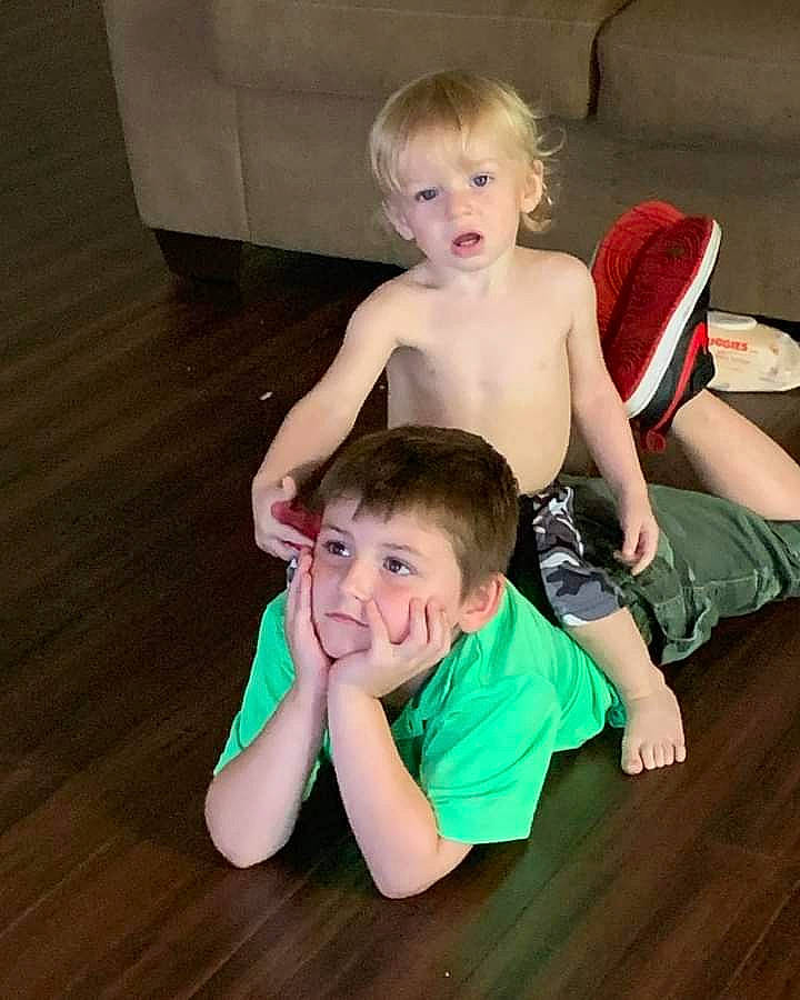 Aiden is registered to the contest to win money with this photo: arm, face, finger, floor, flooring, fun, gesture, hand, happy, head, human_body, joint, leg, muscle, person, shoulder, skin, smile, thigh, toddler