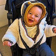 Solal participe au concours pour gagner de l'argent avec cette photo : baby, child, smile, jacket, knit_hat, stroller, happy, infant, clothing, warm, cozy, indoor, person, cute, baby_face, young_child, seated, playful, protected, bundle