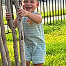 toddler, child, smiling, tree, grass, outdoor, sunlight, romper, happy, baby, fence, car, person, nature, greenery, daylight, portrait, playful, young_child, holding