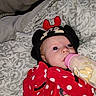 baby, bottle, blanket, clothing, cute, face, hat, infant, lying_down, mickey_mouse, minnie_mouse, person, polka_dots, red, sleepwear, soft_toys, toddler, wearing_hat, white, young_child