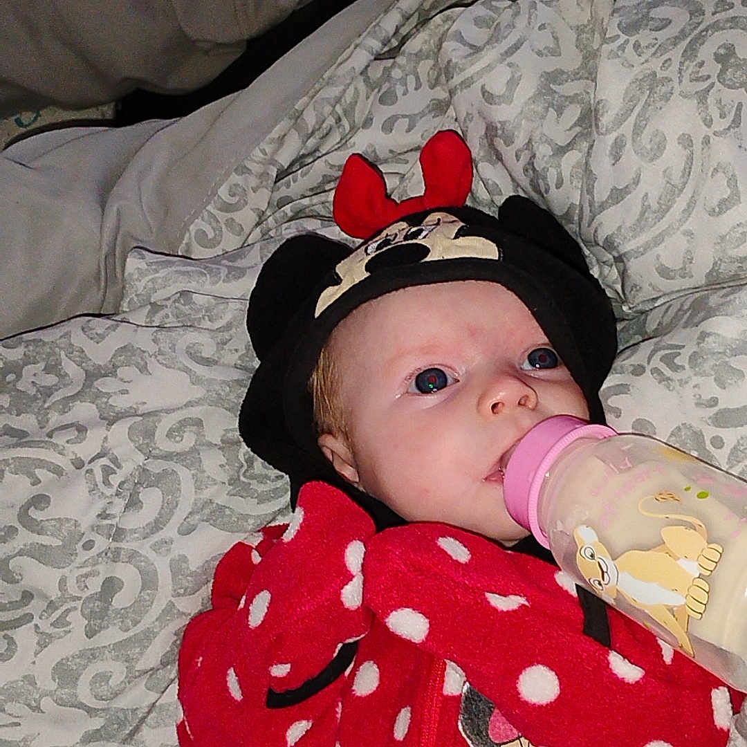 Oaklynn is registered to the contest to win money with this photo: baby, bottle, blanket, clothing, cute, face, hat, infant, lying_down, mickey_mouse, minnie_mouse, person, polka_dots, red, sleepwear, soft_toys, toddler, wearing_hat, white, young_child