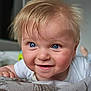 baby, blanket, blonde_hair, blue_eyes, child, close_up, curious, cute, expression, face, hand, happy, indoor, infant, person, portrait, skin, smile, toddler, young_child
