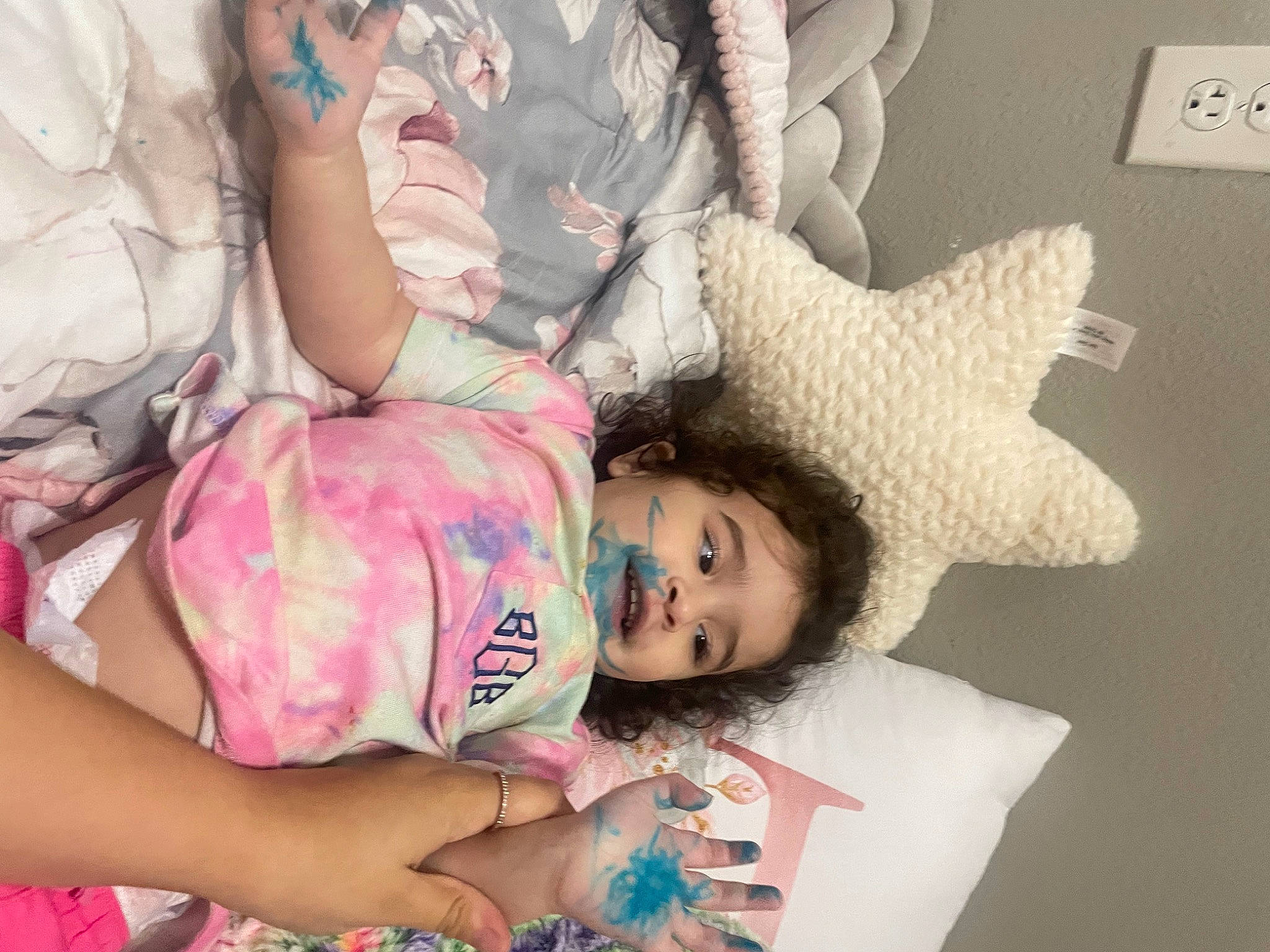 Bailee is registered to the contest to win money with this photo: arm, baby, baby_toddler_clothing, cheek, child, comfort, couch, fun, gesture, hand, happy, linens, magenta, mouth, pattern, person, pink, room, skin, t_shirt