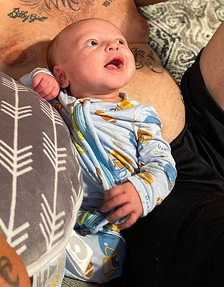 Steel is registered to the contest to win money with this photo: abdomen, baby, baby_toddler_clothing, child, comfort, eye, fun, grass, happy, jewellery, linens, mouth, organ, pattern, person, sitting, skin, sleeve, t_shirt, toddler