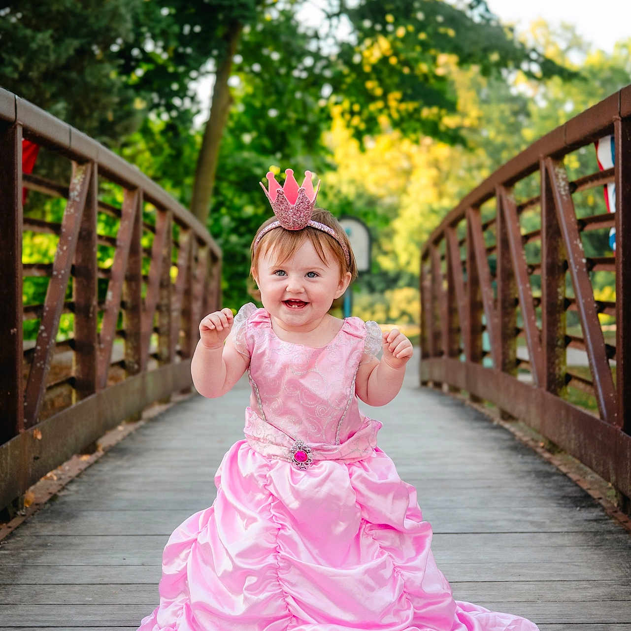 Paislyee joined the competition — help win amazing prizes! baby, bridge, child, crown, cute, daylight, fashion, greenery, happy, headband, nature, outdoor, person, pink_dress, portrait, princess, smiling, toddler, trees, wooden_bridge