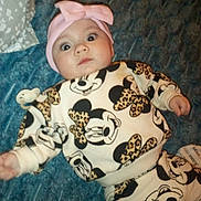 Nariah joined the competition — help win amazing prizes! baby, infant, face, headband, bow, blanket, bed, pillow, onesie, mickey_mouse, leopard_print, pacifier, wide_eyes, surprised, laying_down, clothing, indoor, portrait, cute, newborn