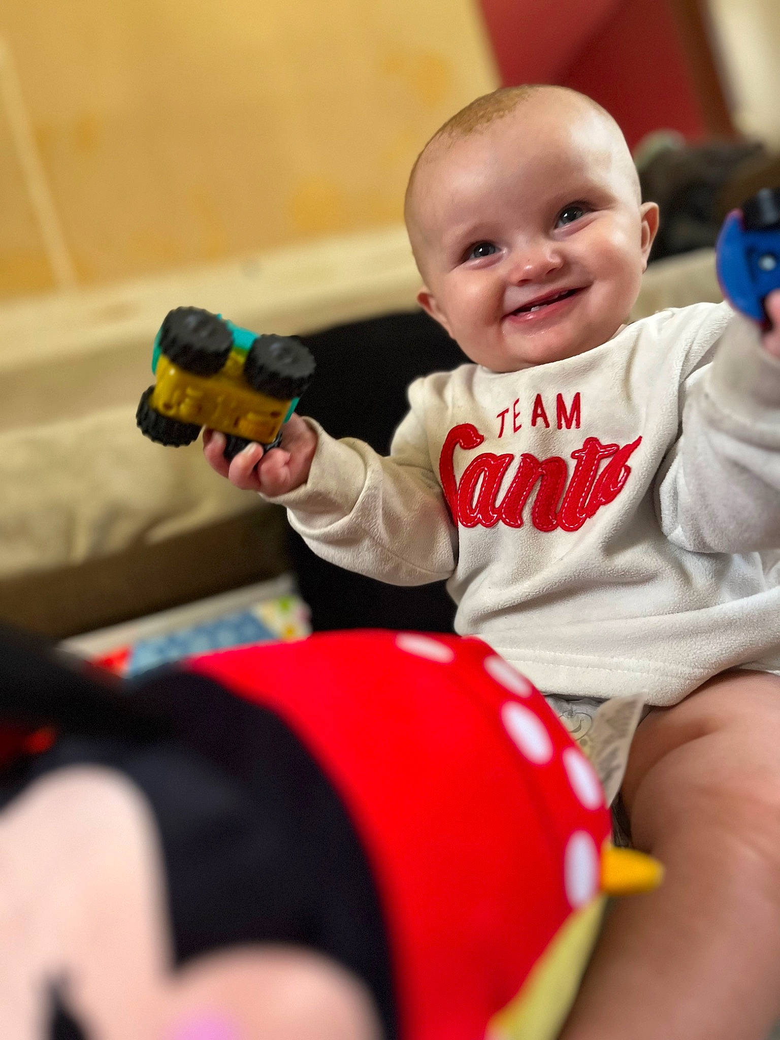 Charlie is registered to the contest to win money with this photo: baby, baby_playing_with_toys, baby_products, baby_toddler_clothing, child, finger, fun, hairstyle, happy, human_body, human_leg, joy, leisure, person, red, sitting, skin, smile, standing, thigh