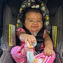 Genesis joined the competition — help win amazing prizes! baby, car_seat, smiling, pink_clothing, socks, child, happy, seatbelt, curly_hair, infant, headrest, patterned_fabric, holding_foot, cute, indoors, safety_harness, toddler, cheerful, playful, seat