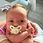Ava-Rose joined the competition — help win amazing prizes! baby, pacifier, infant, closeup, person, pink_clothing, hand, skin, face, newborn, cute, holding, young_child, indoor, soft_light, portrait, expression, curious, human, toddler