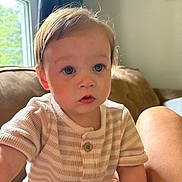 Frankie is registered to the contest to win money with this photo: toddler, child, indoor, couch, window, natural_light, striped_clothing, curious, blue_eyes, soft_light, face, person, young_child, cozy, seated, buttoned_shirt, skin, hair, home, portrait