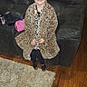 Lilly joined the competition — help win amazing prizes! child, girl, leopard_print, coat, couch, living_room, rug, wooden_floor, smile, sitting, footwear, blanket, sock, furniture, portrait, indoor, home, person, casual, cute